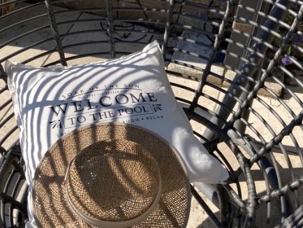 Sonnenhut auf Gartenstuhl mit der Aufschrift: welcome to the pool
